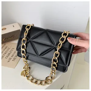 Detailed view of black quilted faux leather bag with geometric stitching and gold chain