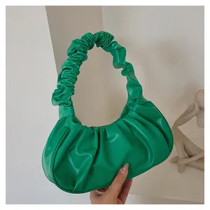 Detail shot of bright green pleated cloud bag with scrunchie strap and soft PU leather texture