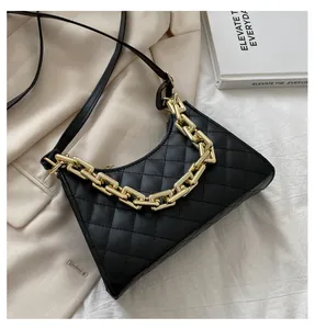 Détail du sac bandoulière noir matelassé avec chaîne dorée et texture en similicuir