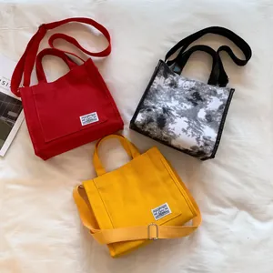 Three minimalist canvas tote bags in red yellow and marble print with adjustable straps