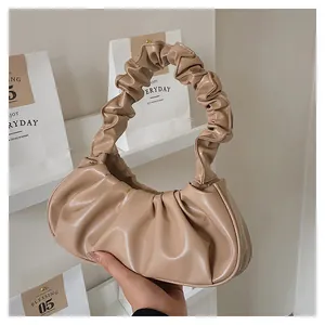 Detail of light beige pleated crescent bag with soft ruched handle and smooth PU texture
