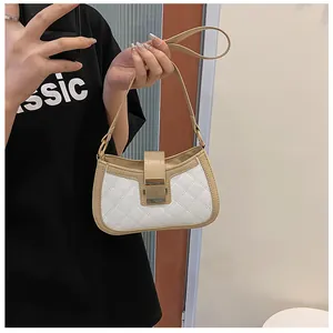 Détail du sac matelassé en similicuir blanc avec bordure beige et boucle dorée