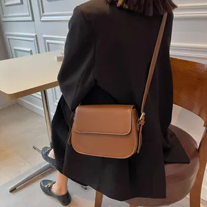 Deep brown saddle bag styled with a black blazer for a professional look