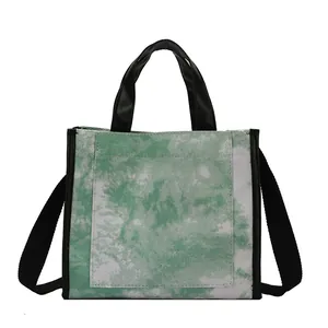 Green and white marble tie-dye canvas tote bag with black handles and shoulder strap