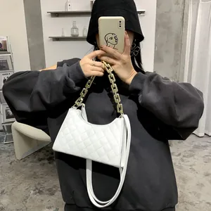 Sac à bandoulière matelassé blanc avec chaîne dorée et cuir sur tenue minimaliste noire