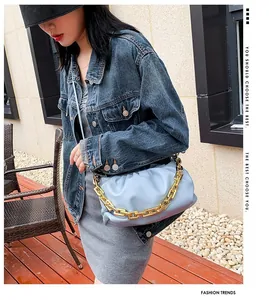 Close-up of light blue pleated cloud bag with chunky gold chain strap on a model