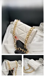 Detail of white quilted crossbody bag with stylish gold chain strap and triangle pattern