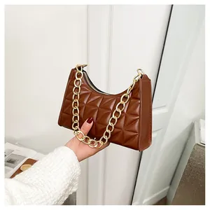 Detail of vintage brown quilted leather shoulder bag with chunky gold chain strap