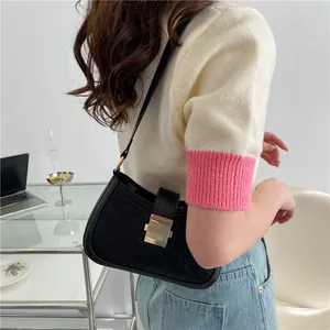 Sac à bandoulière matelassé noir chic avec fermoir doré porté par un mannequin femme