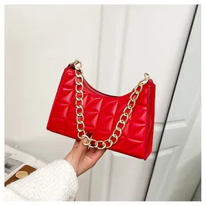 Close-up of red quilted faux leather underarm bag with decorative gold chain strap