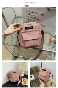 Detail of pink corduroy crossbody bag featuring a woven logo label and flap pocket design
