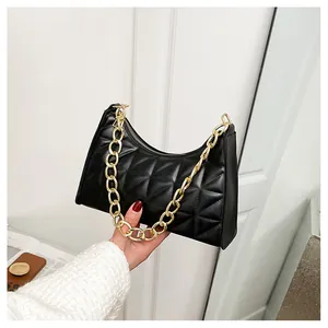 Detail shot of black quilted faux leather bag with thick gold chain decoration