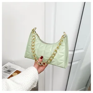 Close-up of light green quilted faux leather bag with chunky gold chain handle detail