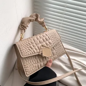 Chic beige crocodile embossed handbag with trendy ruched handle and gold clasp