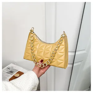 Detailed close-up of yellow quilted leather handbag with gold chain strap and stitching