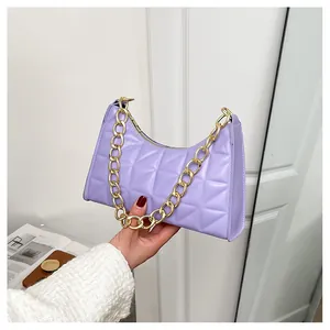 Close-up of purple quilted crossbody bag with chunky gold chain strap and zipper