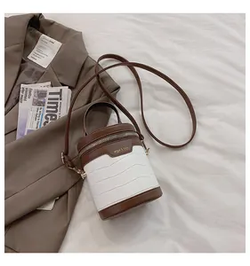Detail der Retro-Zylindertasche aus weißem Krokodilleder und braunem Kontrastleder