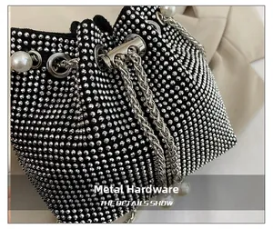 Close-up of black bucket bag with silver rhinestones, metal drawstring and pearl detail