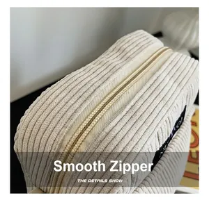 Macro shot of smooth metal zipper detail on cream corduroy small shoulder bag