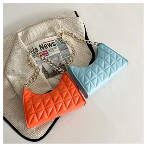 Close-up of quilted crescent shoulder bags in blue and orange with gold chain detail