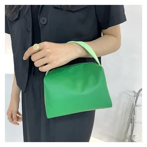 Macro shot of bright green faux leather handbag with soft structure and single top handle