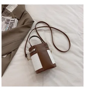 Detail der Zylindertasche mit braunem Kontrast-Design und Kroko-Prägung aus Leder