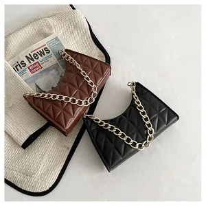 Close-up of quilted crescent shoulder bags with chunky gold chain straps in black and brown