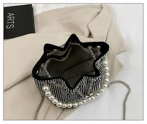 Interior view of black rhinestone bucket bag showing lining, zipper pocket, and pearl handle