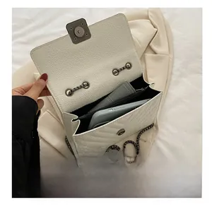 Internal view of a white leather crossbody bag showing spacious capacity for phone and wallet