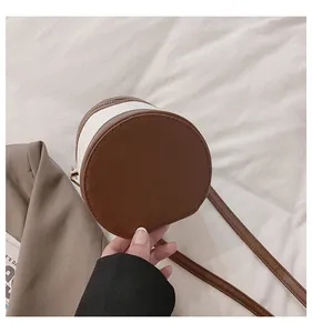 Detailansicht der zylindrischen Handtasche in Kontrastfarben mit goldenem Reißverschluss