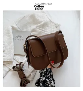 Detailed view of brown retro saddle bag with gold metal buckle and adjustable straps
