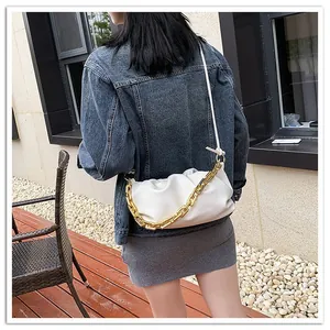 Detailed view of white pleated cloud bag with chunky gold chain strap for women