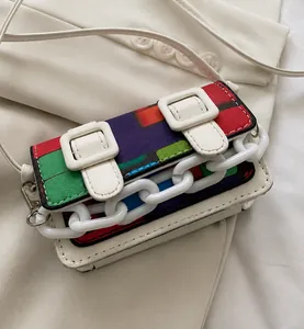 Macro detail of mini crossbody bag with colorful mosaic pattern and chunky white chain