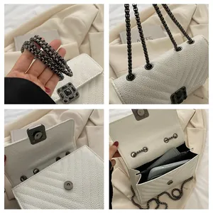 Detail view of white quilted leather crossbody bag with chain strap and interior pockets