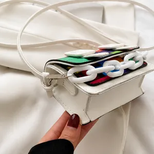 Detailed side view of mini crossbody bag with colorful mosaic flap and white chain