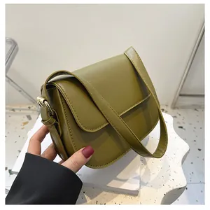 Detailed close-up of olive green crossbody saddle bag with gold metal hardware buckle