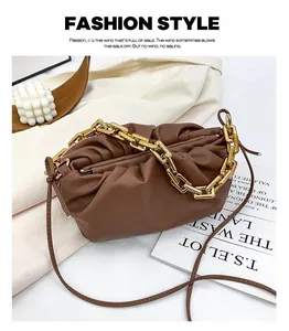 Detail of brown ruched cloud bag with decorative chunky metal chain and soft leather texture