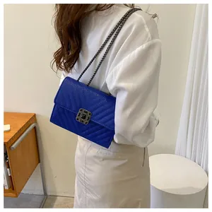 Close-up of royal blue quilted leather chain bag with jewel-encrusted twist lock detail