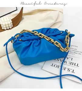 Detail of blue matte leather pouch bag with gold chunky chain and pleated closure