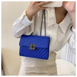 Mirror selfie showing royal blue quilted leather crossbody bag with jewelry buckle