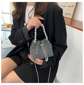 Detail of blue gradient rhinestone bucket bag with large pearl handle and metal chain