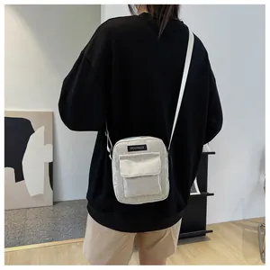 Minimalist white corduroy crossbody square bag for women worn by a model in casual setting