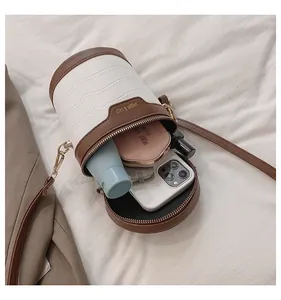 Innenansicht zeigt die große Kapazität der weißen Zylinder-Handtasche mit Krokoprägung
