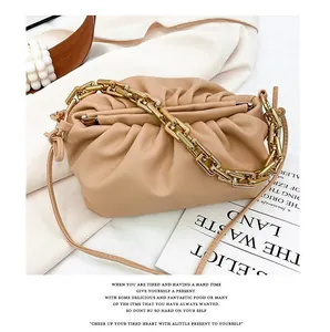 Detail shot of beige ruched cloud bag with chunky gold chain on fashion magazine