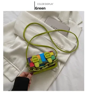 Detail of mini color-block crossbody bag with green buckles and thick chain strap