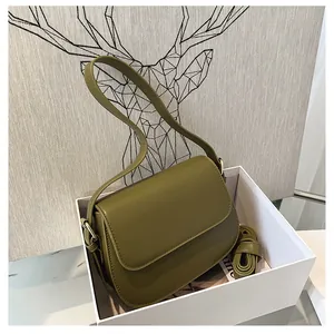 Detailed top view of olive green faux leather saddle bag inside a premium white gift box