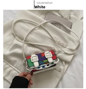Detail of colorful geometric crossbody bag with white chain and leather strap