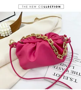 Detail of fuchsia pleated cloud bag with chunky gold chain strap and leather shoulder strap