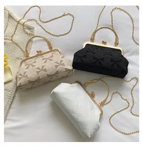 Detail of vintage evening bags with bow patterns, metal ring handles and gold chains