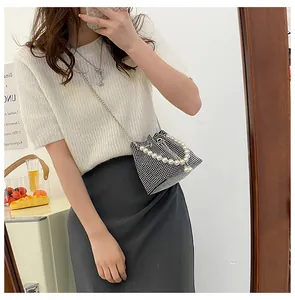 Mirror selfie showing the scale of a black bucket bag with rhinestones and pearl handle